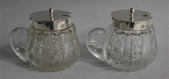 A pair of Edwardian silver mounted cut glass single handled preserve jars, A.C.M & Co, Birmingham, 1905, 72mm.